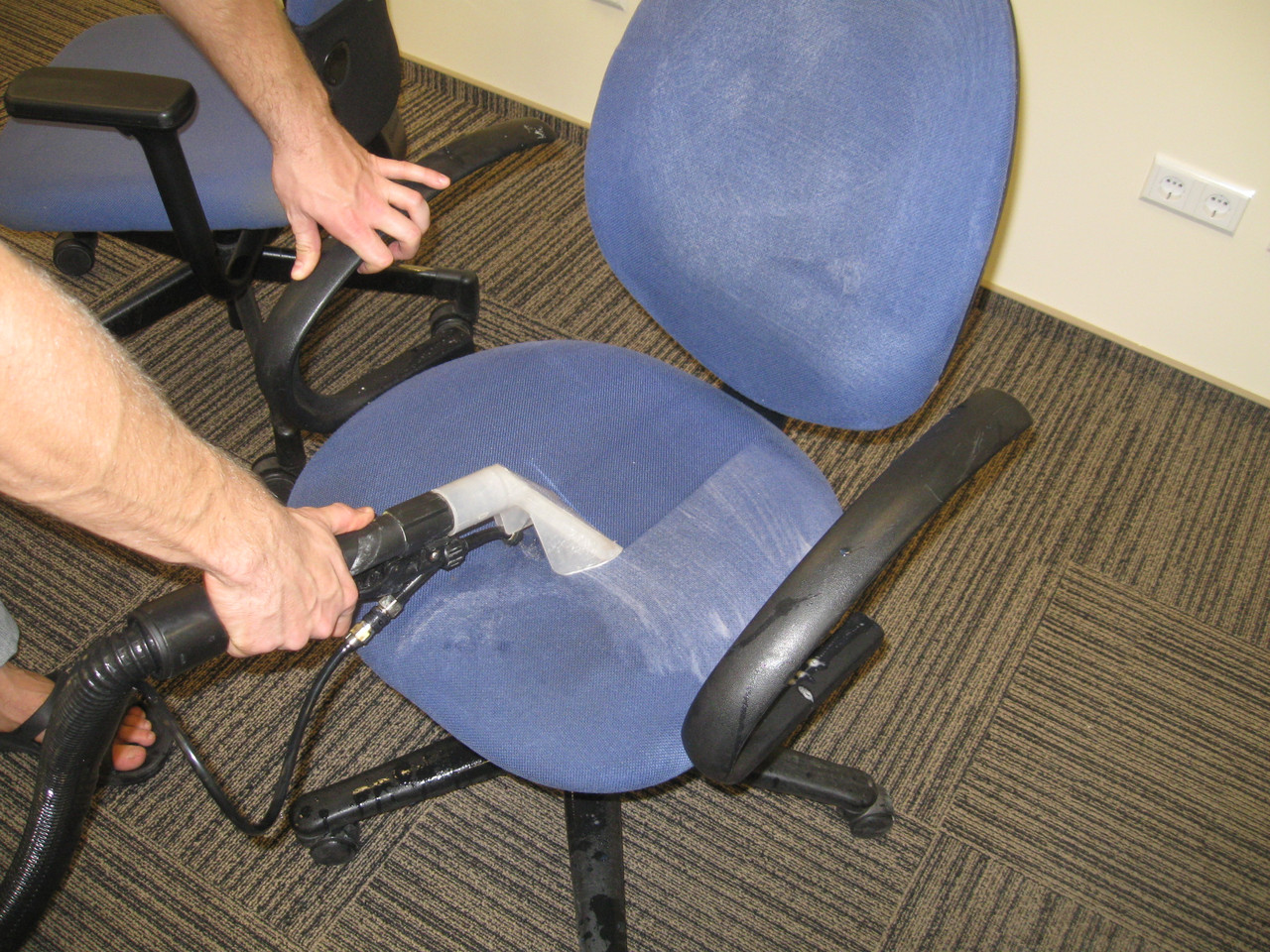 Мастер очищает офисные кресла